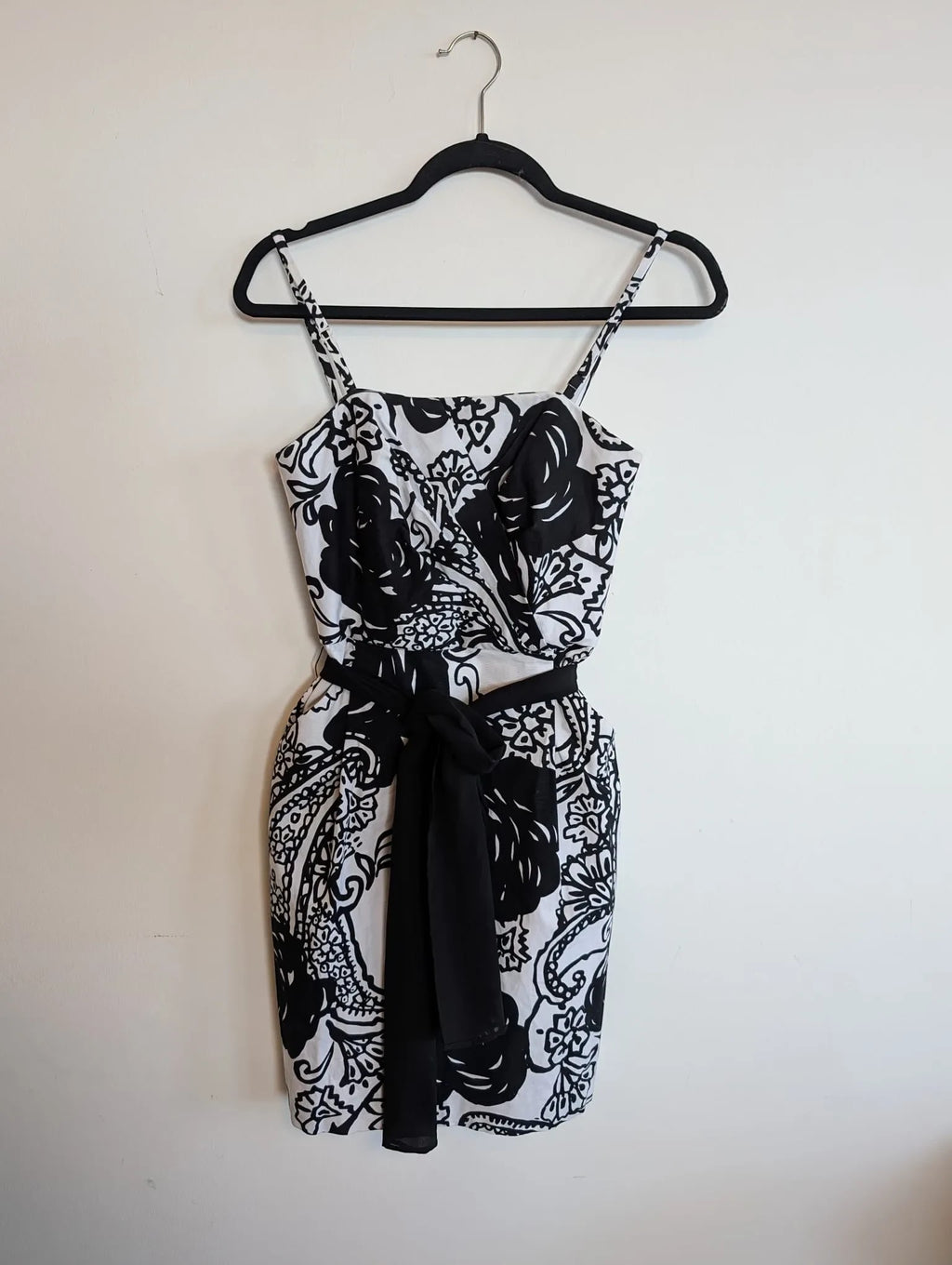 Nu-Nv Clothing black and white floral print sleeveless mini dress with a square neckline and black waist tie.